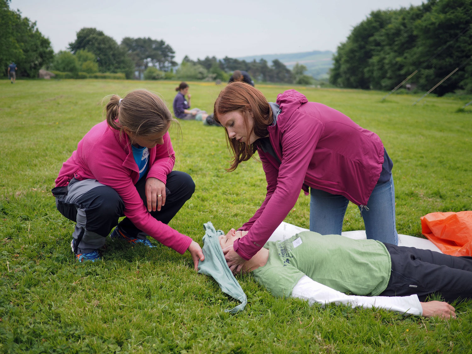 2 adults performing first aid